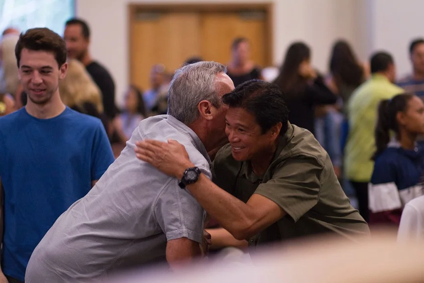 Two men are socializing at a residential community event.